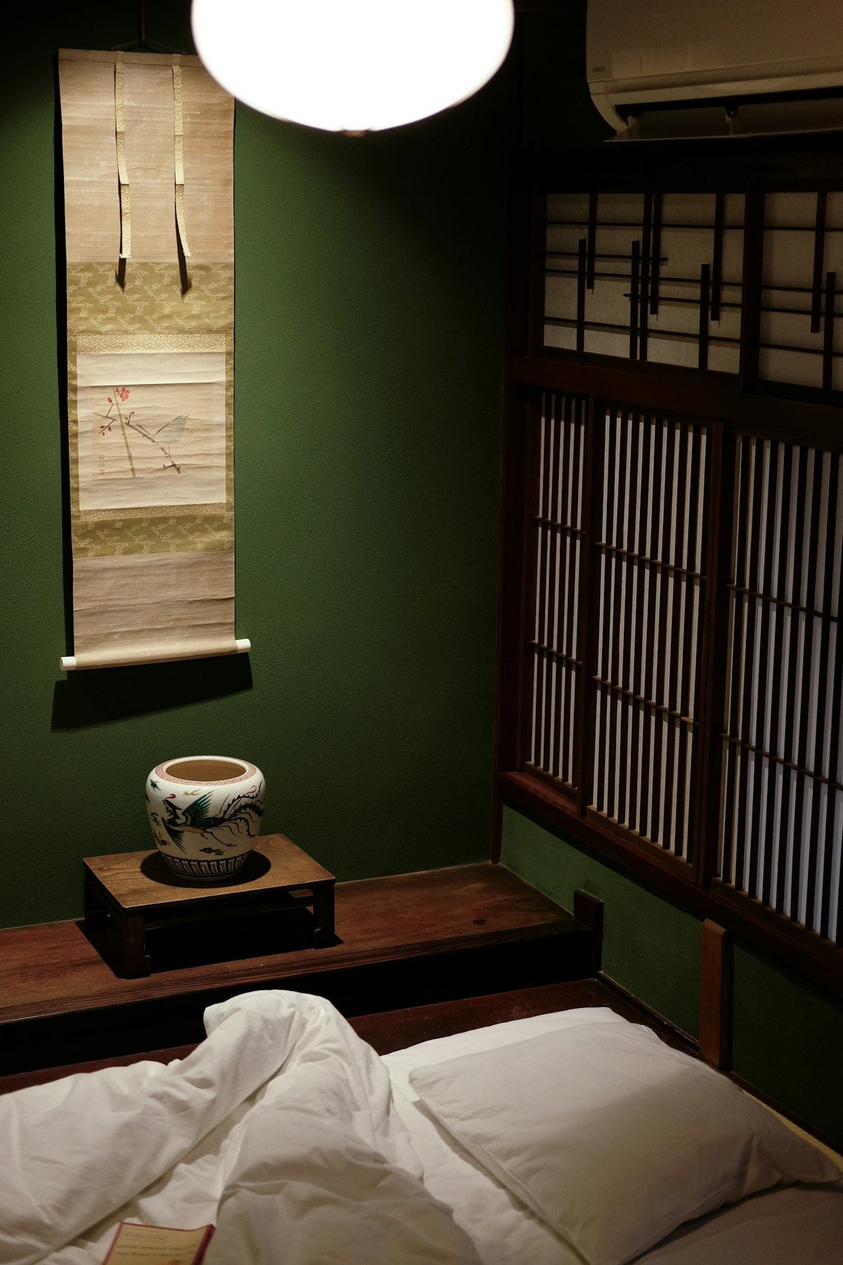 Chambre japonaise traditionnelle avec futon au sol et lumière douce