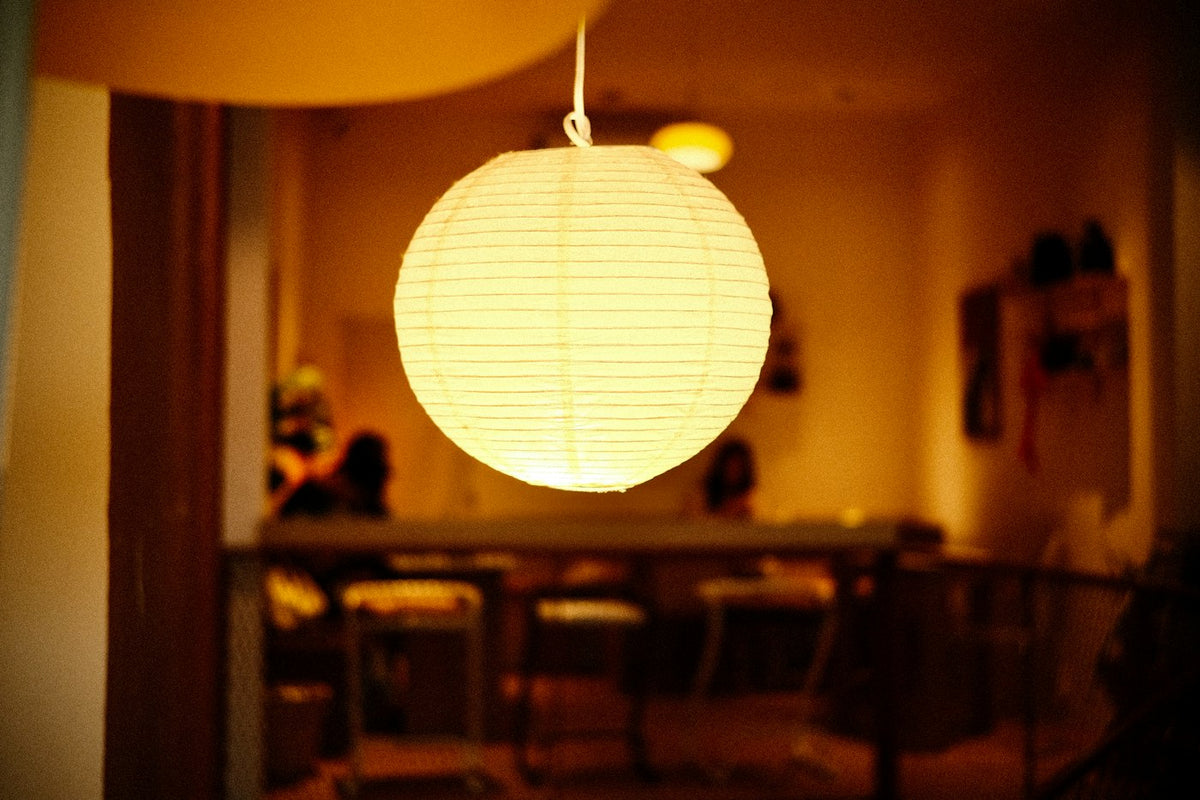 Lampe japonaise en papier de riz allumée dans un intérieur chaleureux