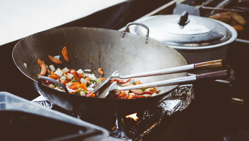 Wok en acier noir et légumes sautés